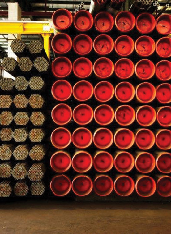 Stacked steel pipes with protective red end caps stored in Tatlian Hardware warehouse Singapore